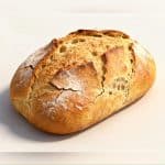 Crusty keto bread loaf sliced on a wooden board, golden brown, low-carb and gluten-free