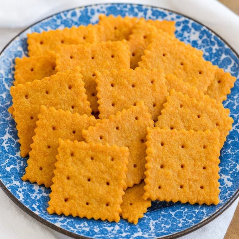 Golden crispy cheddar cheese crackers arranged on a blue speckled plate
