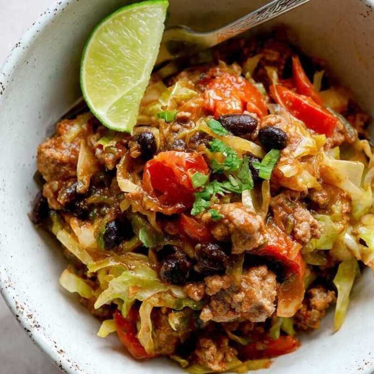 Keto chili black bean pork and cabbage stir-fry served in a bowl with fresh cilantro and lime