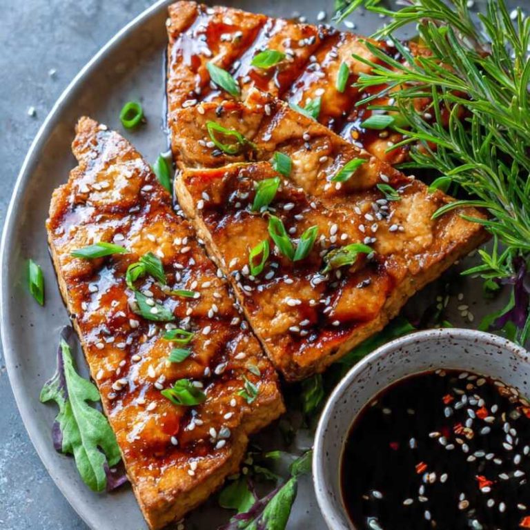 Keto teriyaki tofu steaks glazed with sugar-free sauce and topped with sesame seeds