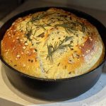 Golden keto rustic rosemary garlic bread with cracked crust baked in a cast iron pan